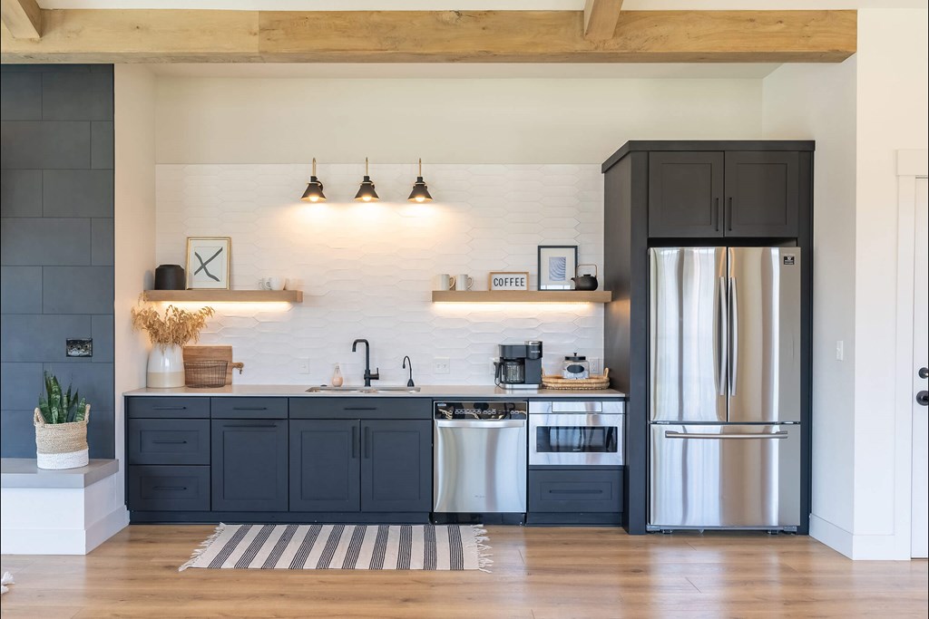 A kitchen with a black fridge and a white sink. A kitchen with a black fridge and a white sink at St Helens Place Apartment Homes, St Helens, OR