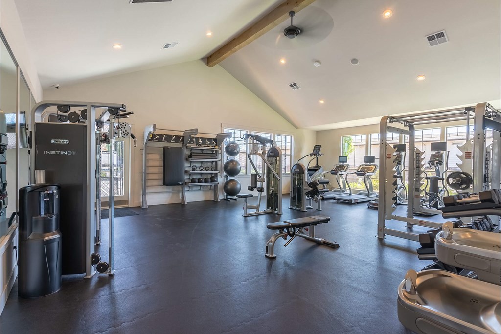 A spacious gym with various exercise equipment and a bench. A spacious gym with various exercise equipment and a bench at St Helens Place Apartment Homes, St Helens, 97051