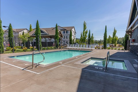 A large outdoor swimming pool with a slide and a hot tub at Timberridge Place Apartment Homes, Oregon, 97322