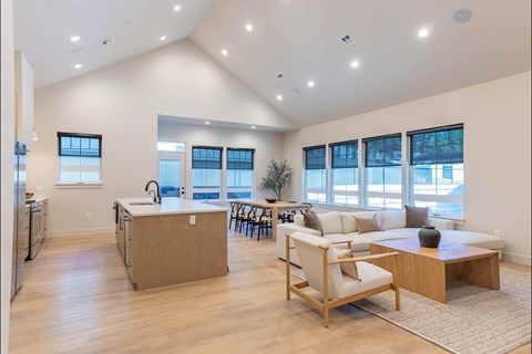 A spacious kitchen with a dining area and a living room with a couch and a coffee table.