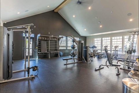 A spacious gym with a variety of equipment including a squat rack, bench, and weights at Westgate Apartment Homes, Pendleton, OR, 97801