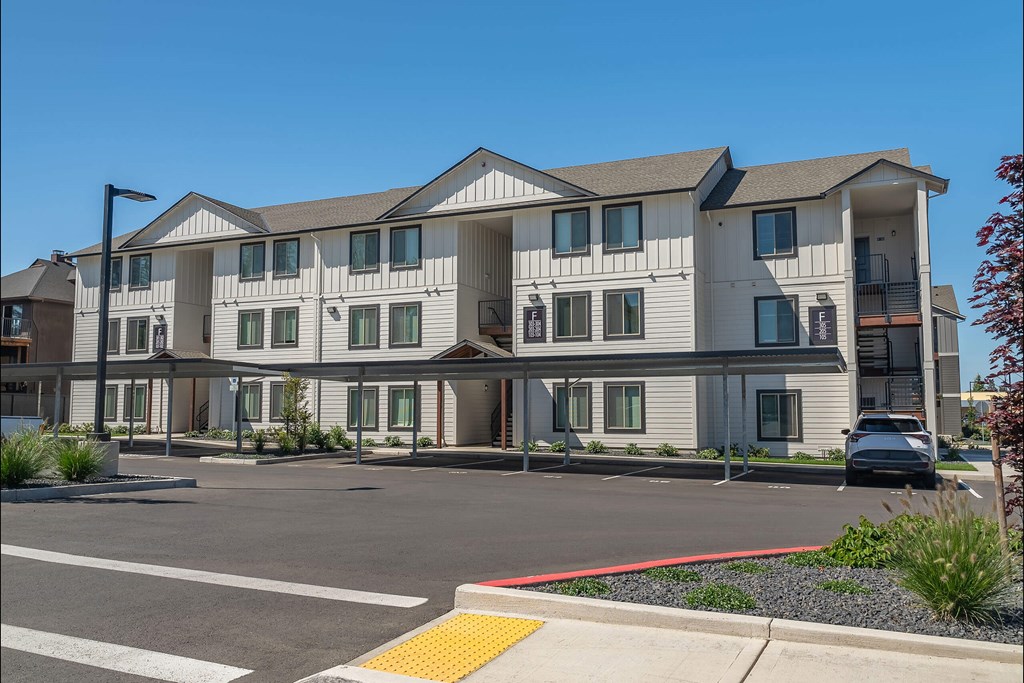A large white building with a red stripe on the side. A large white building with a red stripe on the side at Cascade Place Apartment Homes, Molalla