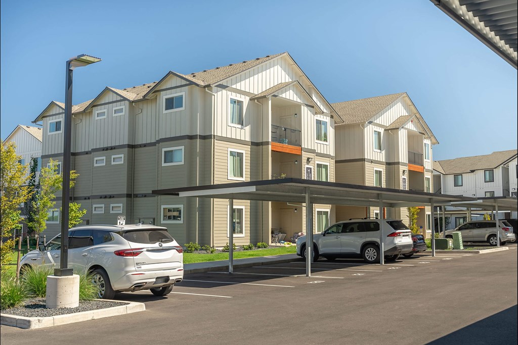 A row of townhouses with cars parked in front at Cascade Place Apartment Homes, Molalla, 97038