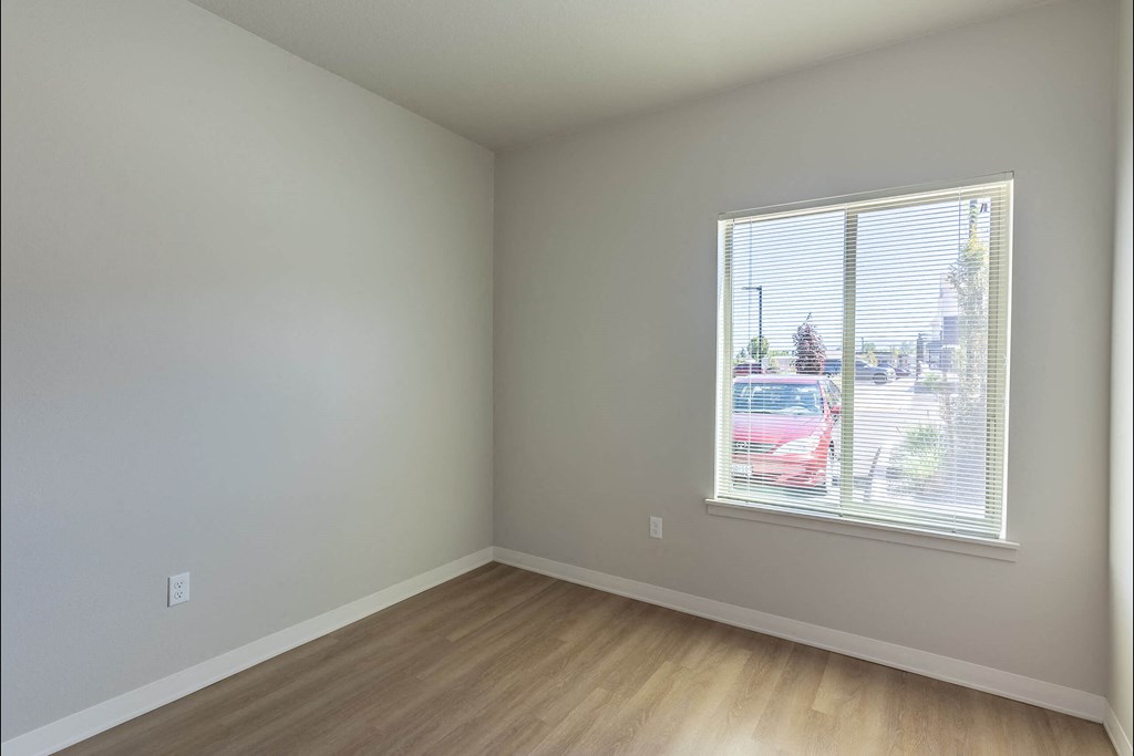 A room with a window showing a red car outside at Cascade Place Apartment Homes, Molalla, OR