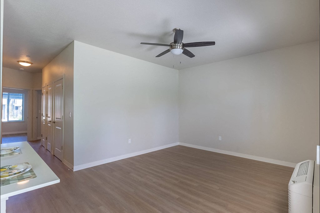 A room with a ceiling fan and a wood floor at Cascade Place Apartment Homes, Molalla, OR, 97038