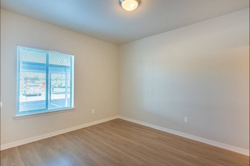 A room with a window and wooden flooring at Cascade Place Apartment Homes, Molalla, OR