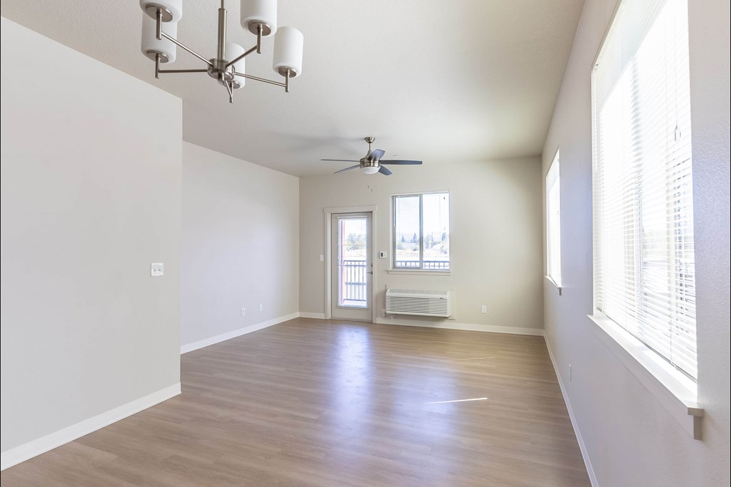 A room with a ceiling fan and a chandelier at Cascade Place Apartment Homes, Molalla, 97038
