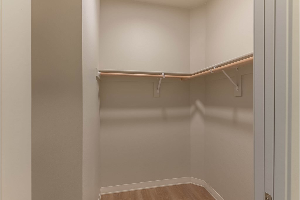 A small, empty closet with a wooden floor and white walls at Cascade Place Apartment Homes, Oregon, 97038