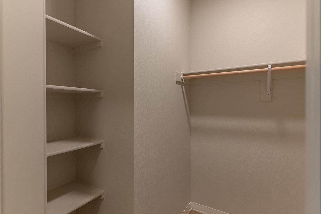A white closet with shelves and a hanger at Cascade Place Apartment Homes, Molalla, 97038