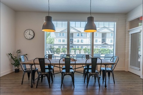 A dining room with a table and chairs.