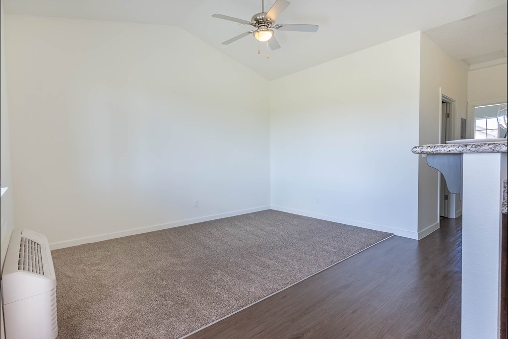 A room with a ceiling fan and a carpeted floor at Riverplace Apartment Homes, Independence