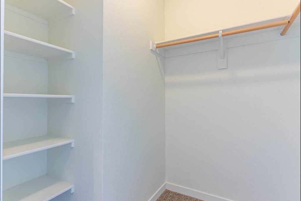 A white pantry with shelves and a white wall at Riverplace Apartment Homes, Independence, OR, 97351