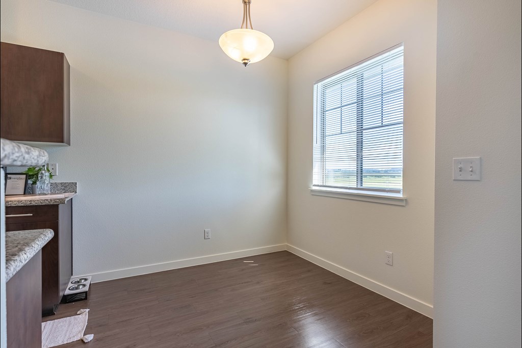 A room with a window and a hanging light fixture at Riverplace Apartment Homes, Oregon