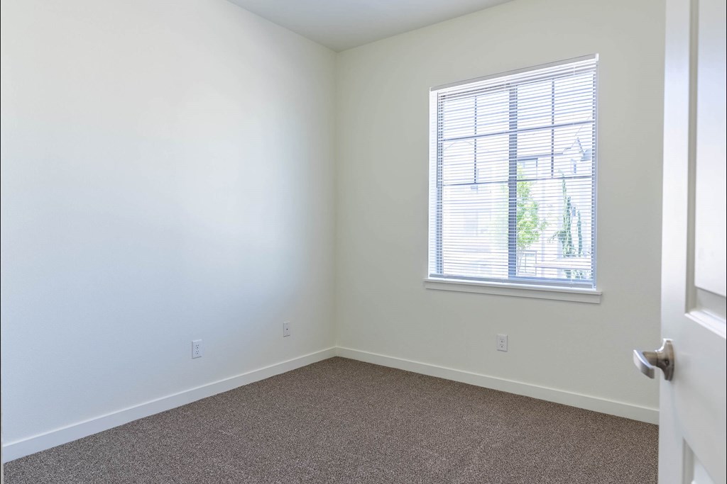 A room with a carpeted floor and a window with blinds at Riverplace Apartment Homes, Independence, 97351