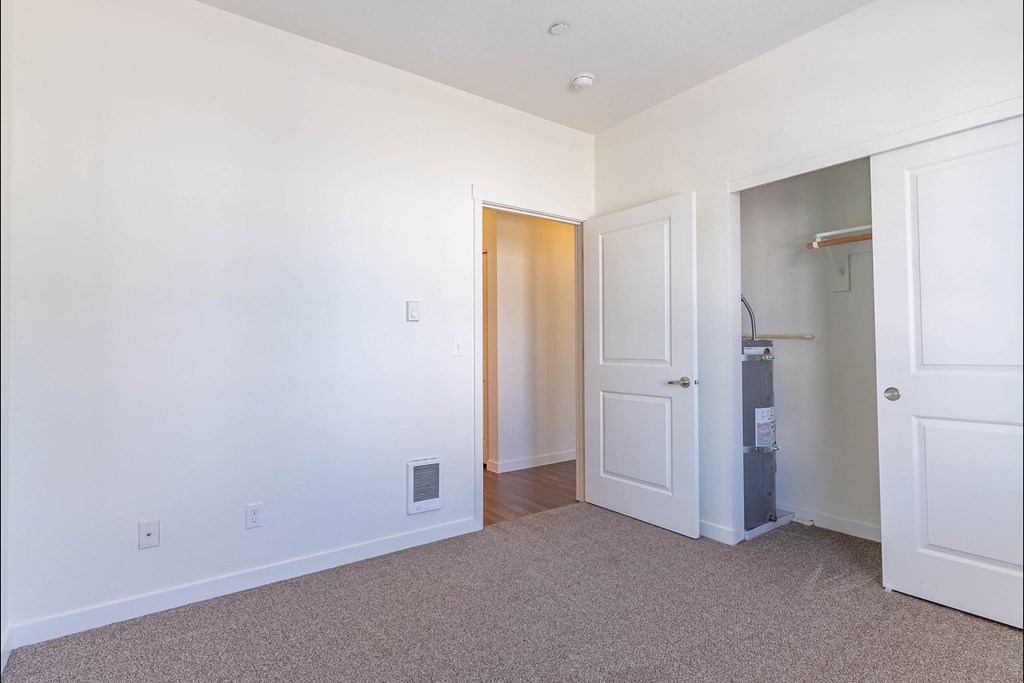 A white room with a door and a small cabinet at Riverplace Apartment Homes, Independence, OR, 97351