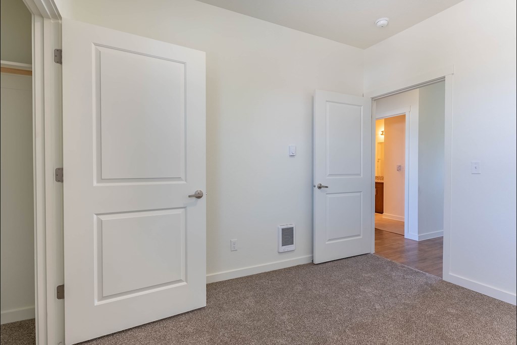 A white door is open to a hallway at Riverplace Apartment Homes, Independence, 97351