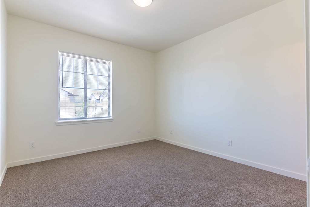 A room with a carpeted floor and a window at Riverplace Apartment Homes, Oregon, 97351