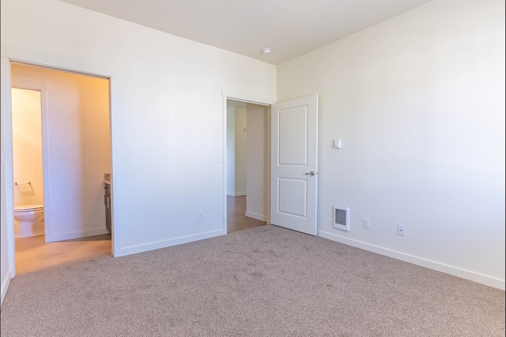 A large, empty room with carpeted flooring and white walls at Riverplace Apartment Homes, Independence, OR