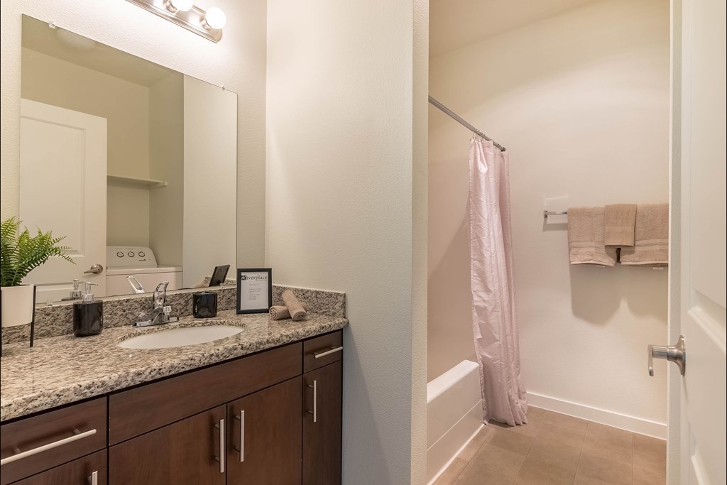 A bathroom with a sink, mirror, and towel rack at Riverplace Apartment Homes, Independence, 97351
