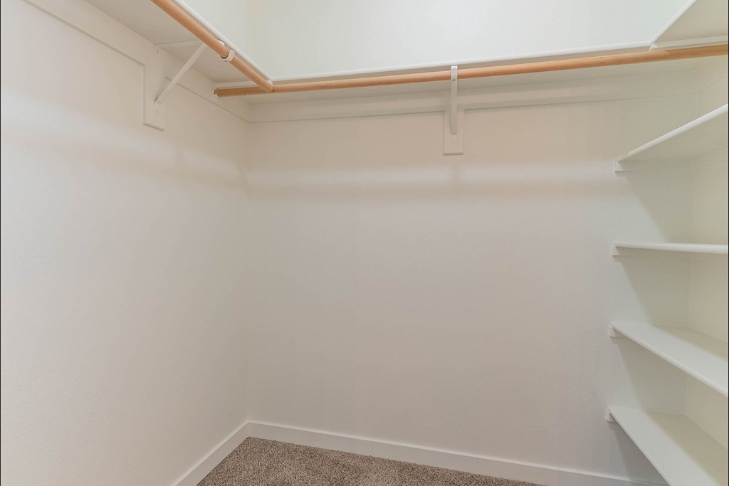 A white room with a carpeted floor and a staircase on the right side at Riverplace Apartment Homes, Oregon, 97351