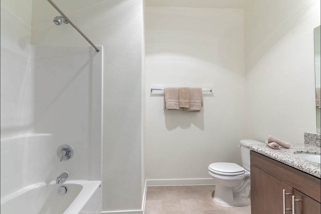 A white bathroom with a toilet, sink, and bathtub at Riverplace Apartment Homes, Oregon
