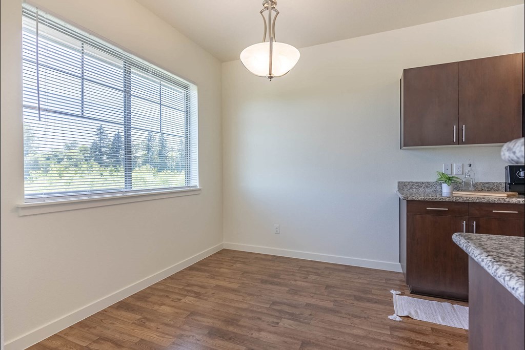 A kitchen area with a window and wooden flooring at Riverplace Apartment Homes, Independence, OR, 97351
