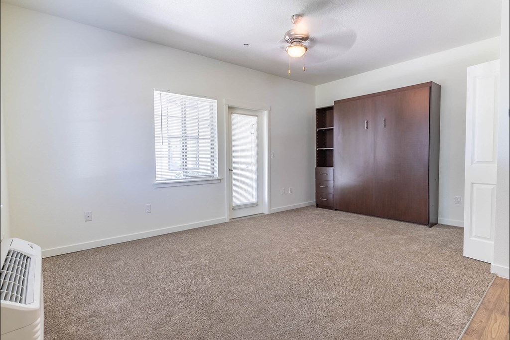 A room with a brown wardrobe and a window with blinds at Riverplace Apartment Homes, Independence, OR, 97351