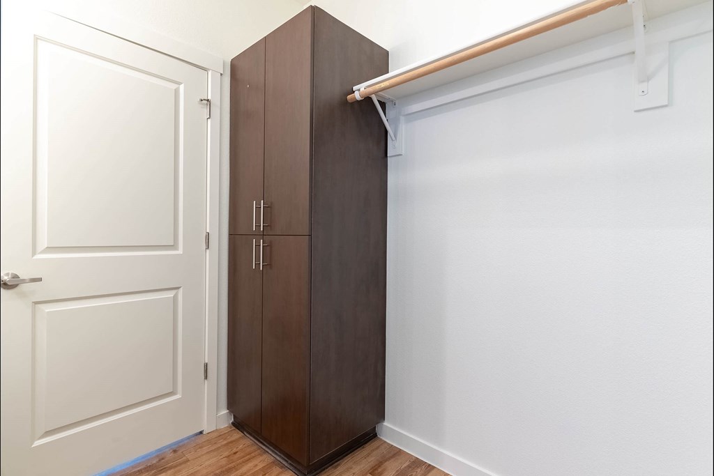 A brown wardrobe is in a white room at Riverplace Apartment Homes, Independence