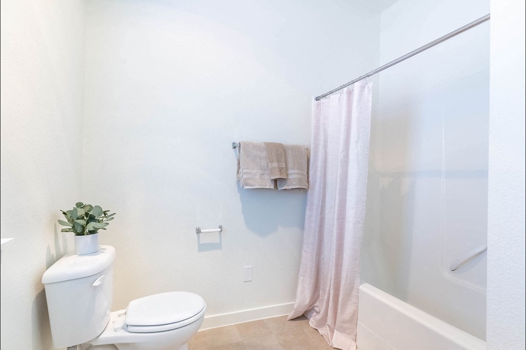 A white toilet sits next to a white sink in a bathroom at Riverplace Apartment Homes, Oregon