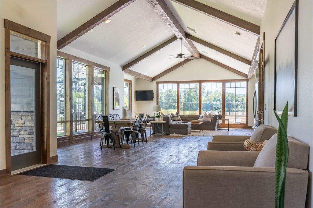 A living room with a stone wall and a ceiling fan at Riverplace Apartment Homes, Independence, 97351
