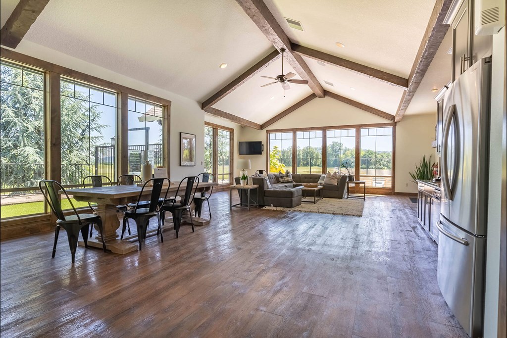 A spacious kitchen and dining area with wooden floors and a large window at Riverplace Apartment Homes, Independence, Oregon