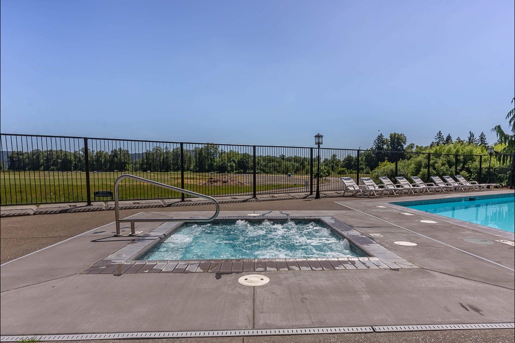 A pool with a hot tub in the middle of it at Riverplace Apartment Homes, Independence