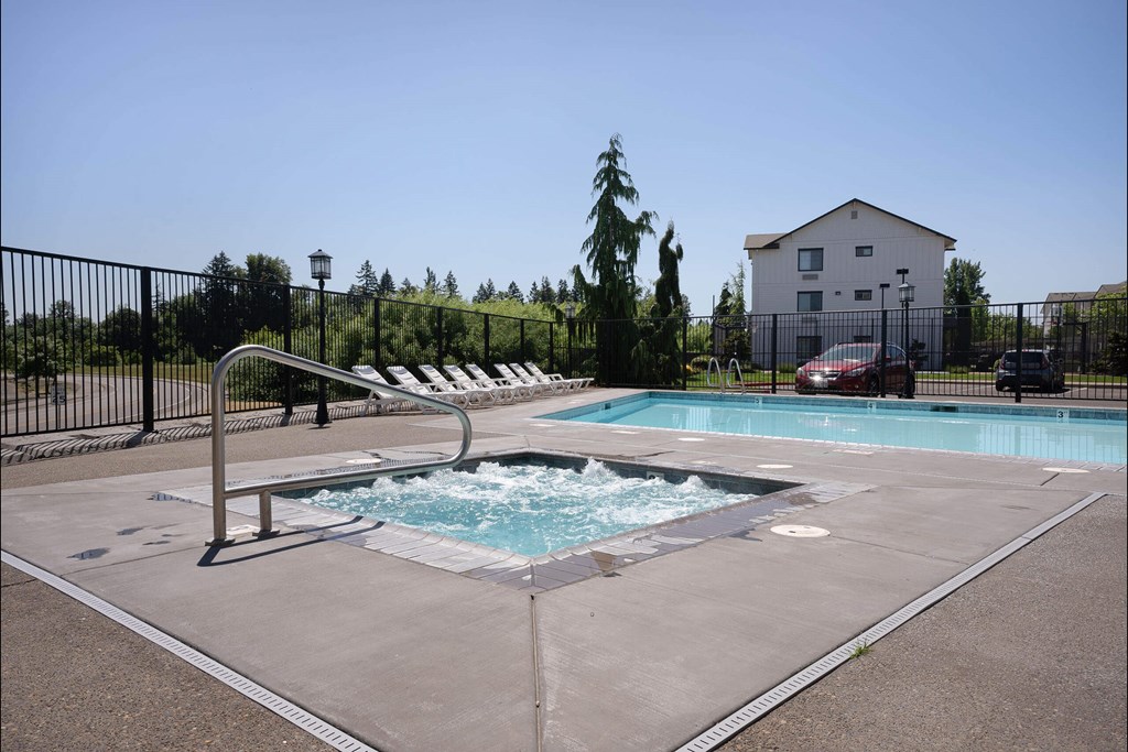 A small pool with a slide and a house in the background at Riverplace Apartment Homes, Independence, OR, 97351