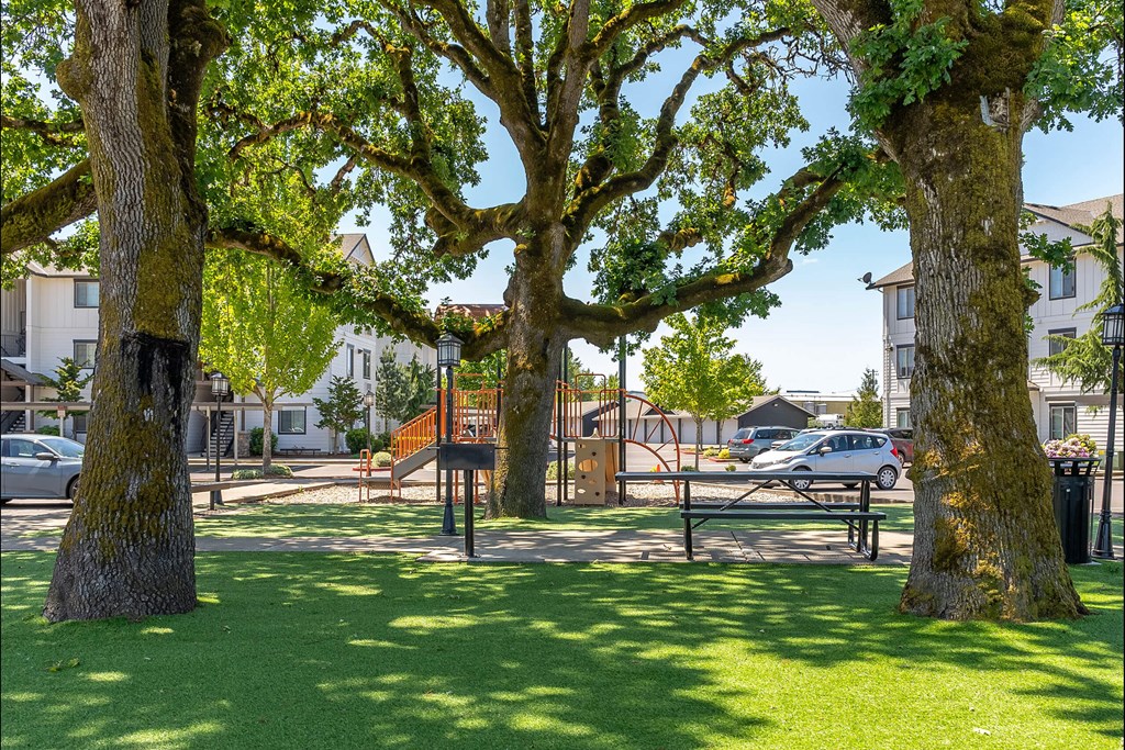 A park with a playground and trees at Riverplace Apartment Homes, Independence, OR, 97351