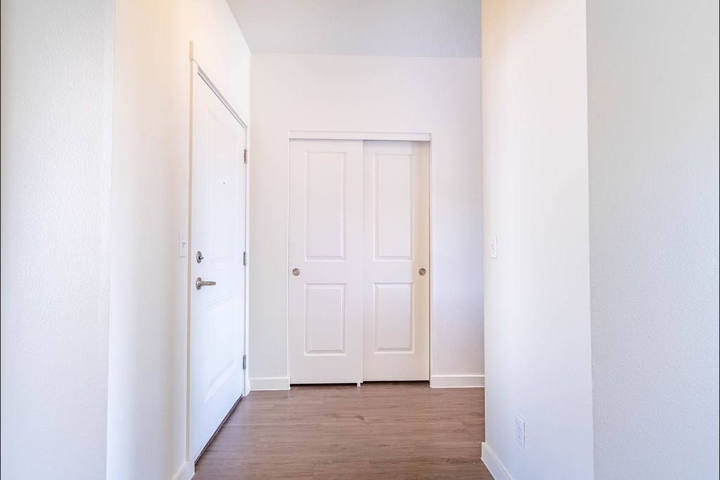 A white door is in the middle of a hallway at Riverplace Apartment Homes, Oregon, 97351