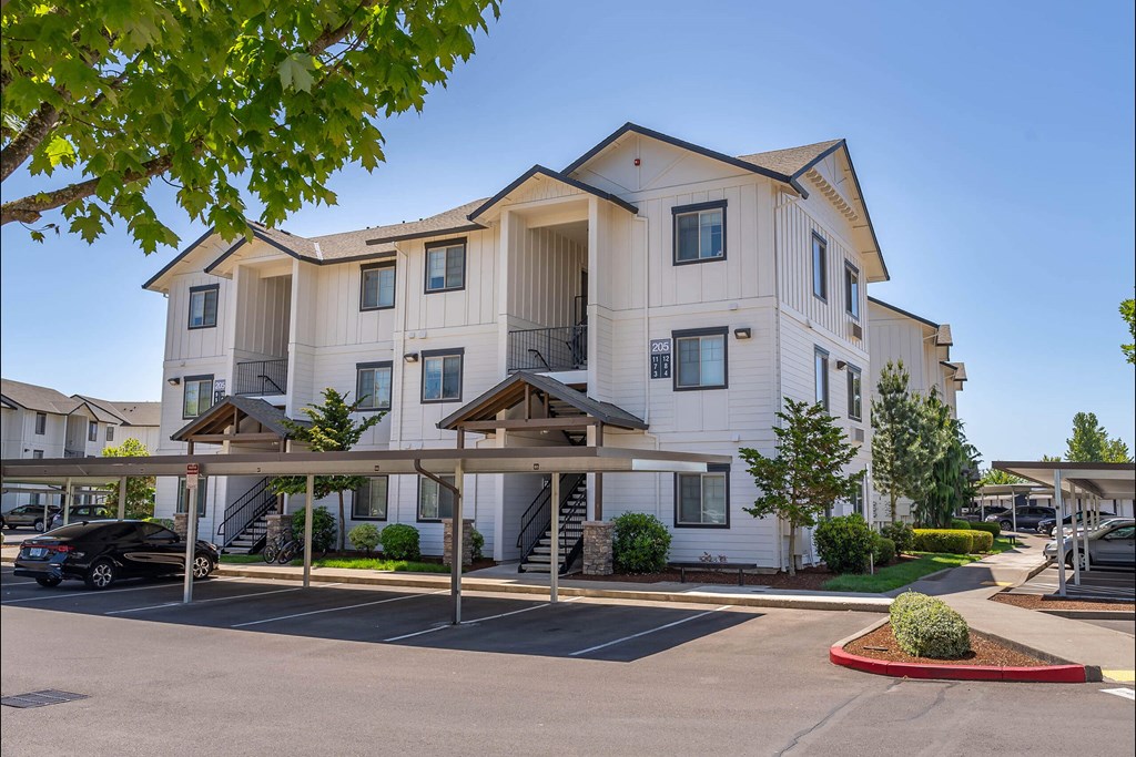 A large white apartment building with a parking lot in front at Riverplace Apartment Homes, Oregon