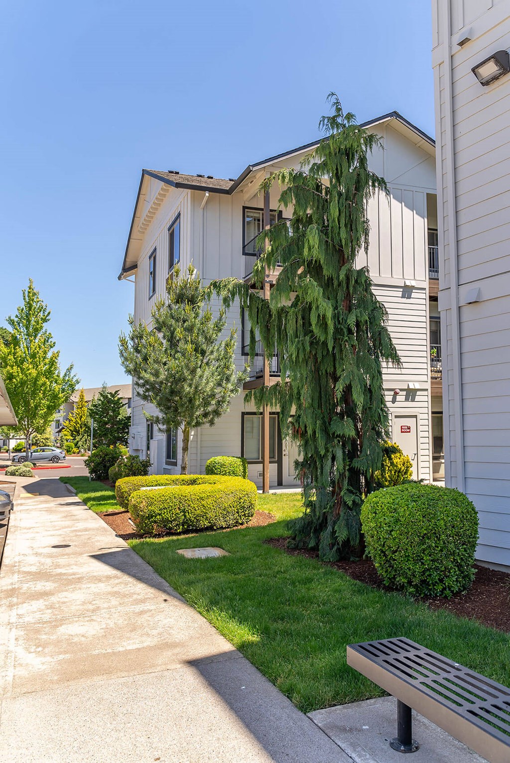 A white building with a tree in front of it at Riverplace Apartment Homes, Independence, 97351