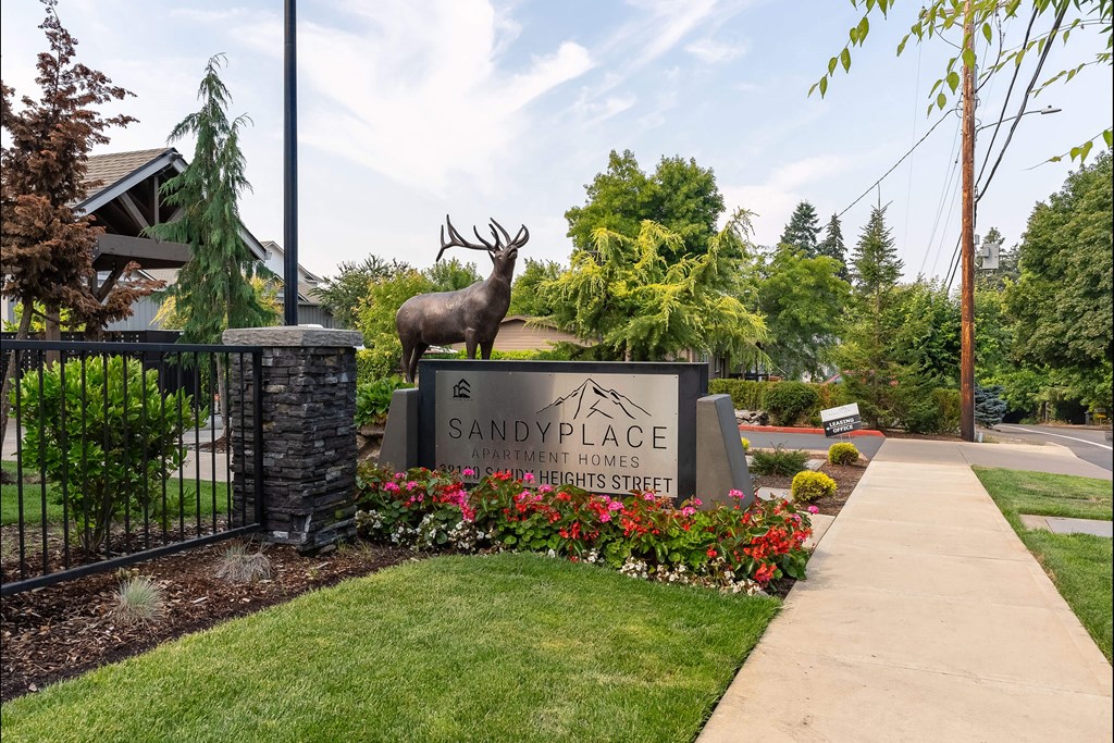 A moose statue stands in front of a sign for Sandy Place Apartment Homes at Sandyplace Apartment Homes, Sandy, Oregon
