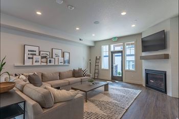 A living room with a grey couch and a fireplace.