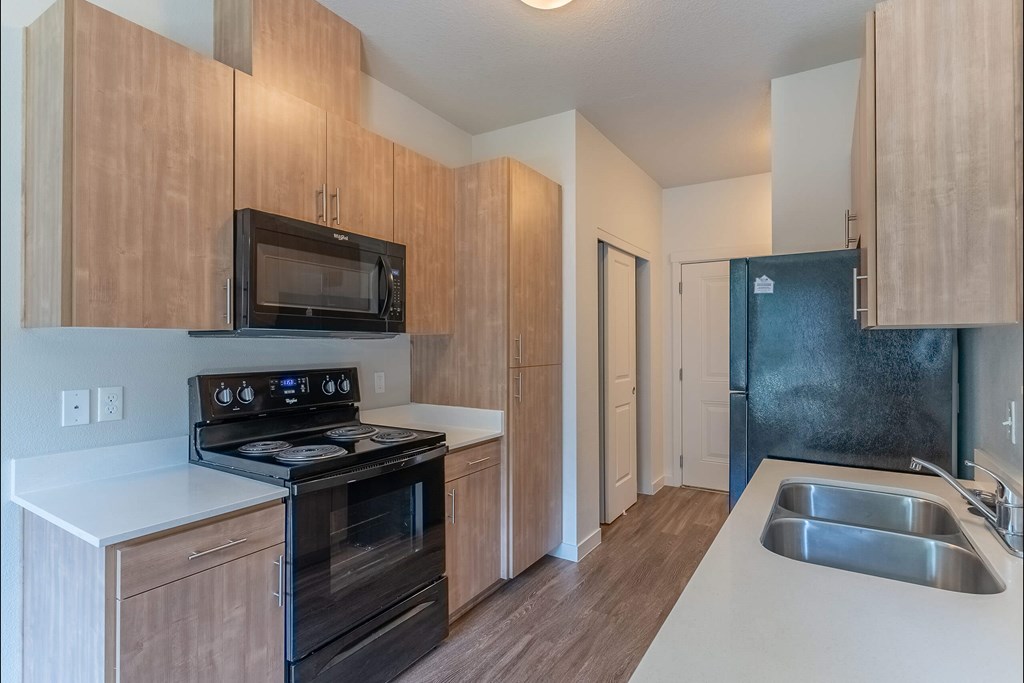 A kitchen with a black stove and microwave at Sandyplace Apartment Homes, Sandy, 97055