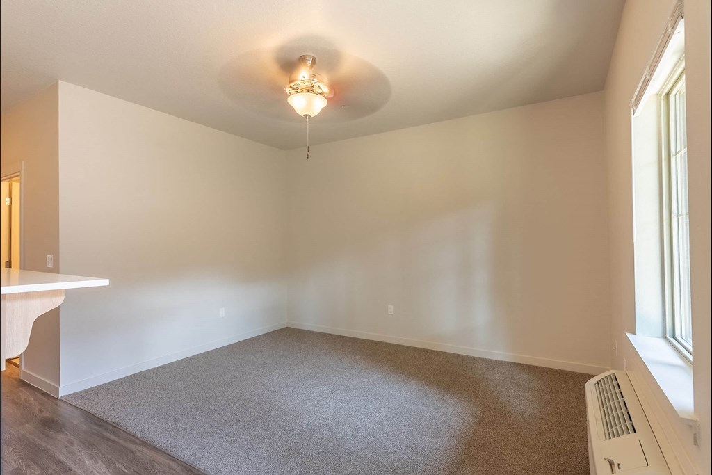 A room with a carpeted floor and a window on the right side at Sandyplace Apartment Homes, Sandy