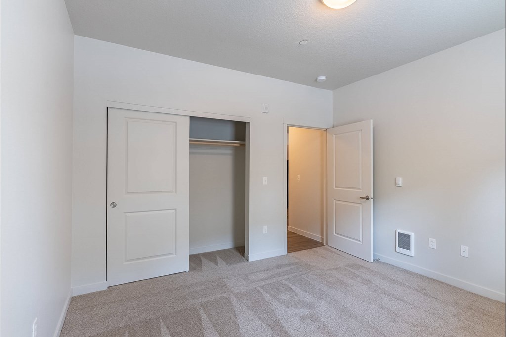 A room with a carpeted floor and two doors at Sandyplace Apartment Homes, Sandy, 97055