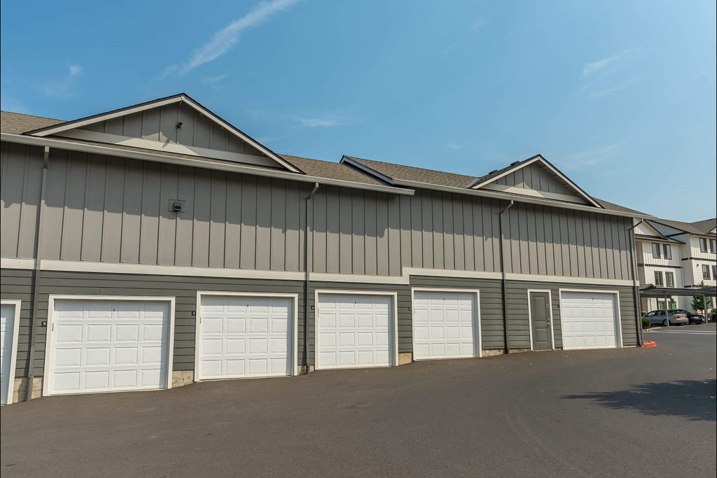 A large industrial building with grey walls and white garage doors at Sandyplace Apartment Homes, Sandy, OR