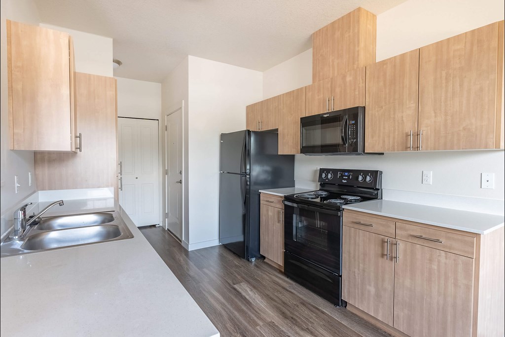 A kitchen with wooden cabinets and black appliances at Silverplace Apartment Homes, Silverton, OR
