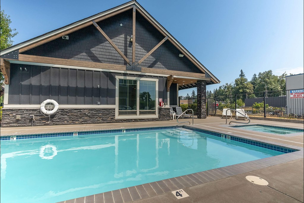 A pool with a house in the background at Silverplace Apartment Homes, Silverton
