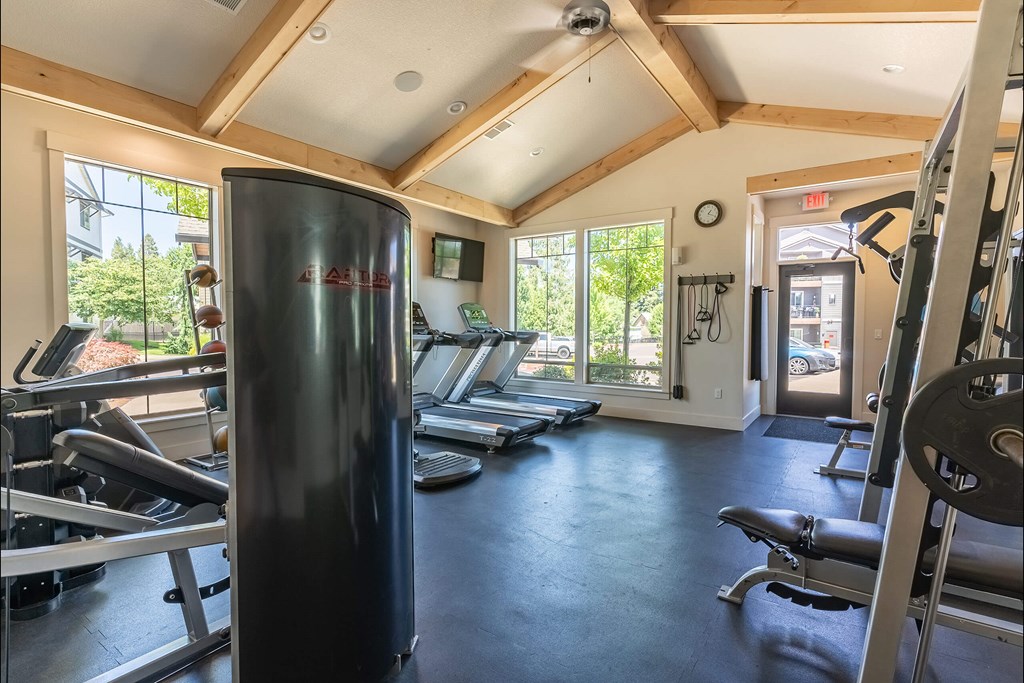 A gym with a row of treadmills and a weight rack. A gym with a row of treadmills and a weight rack at Silverplace Apartment Homes, Silverton, OR