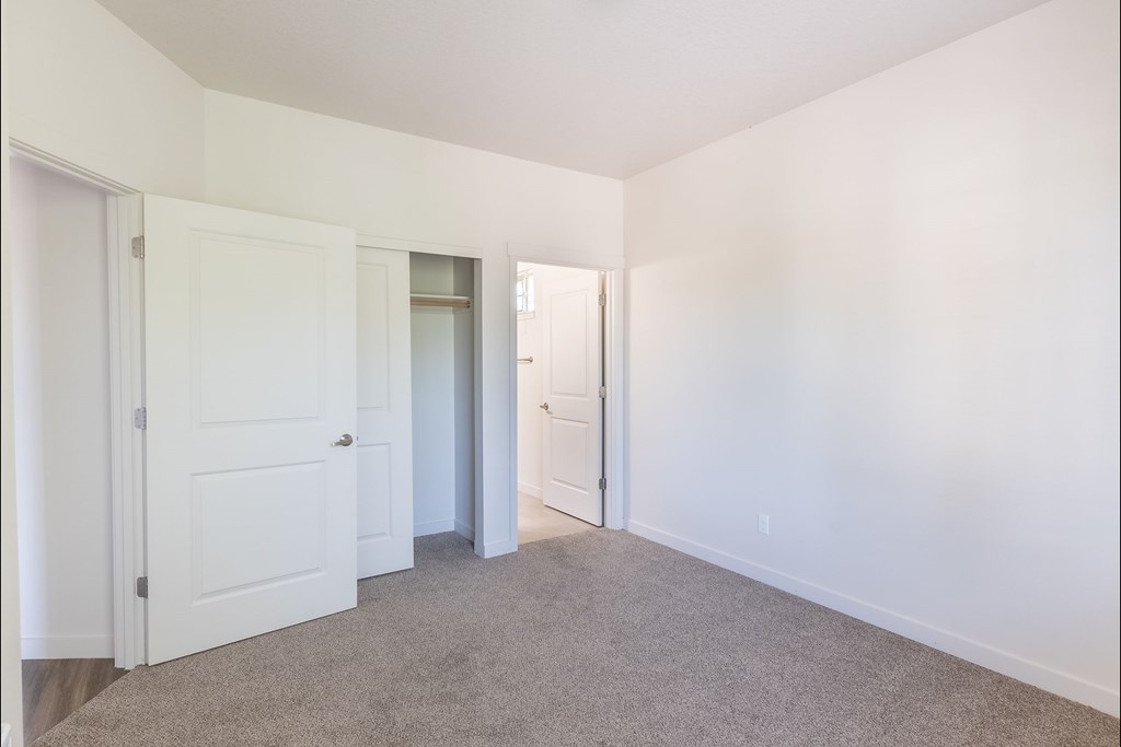 A white door is on the left and a white closet door is on the right at Silverplace Apartment Homes, Silverton, OR, 97381