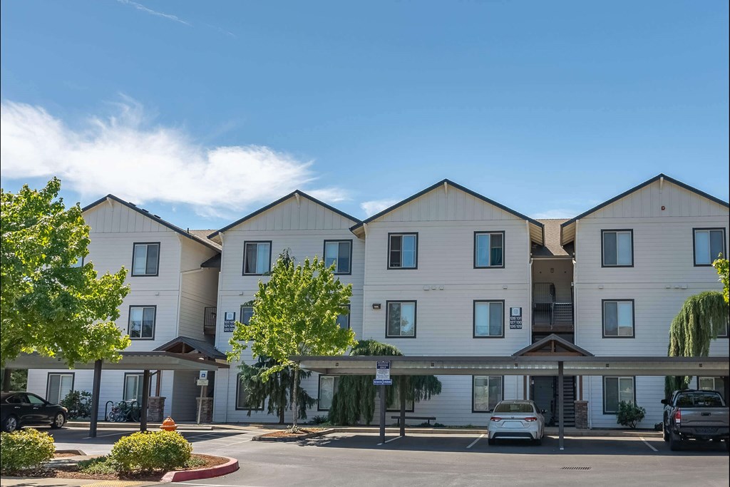 A large white building with a parking lot in front at Stoneplace Apartment Homes, Molalla, OR, 97038
