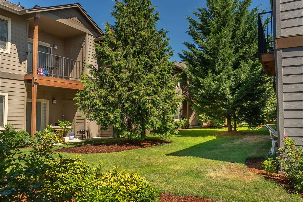 A residential area with a house, trees, and a lawn at Stoneplace Apartment Homes, Molalla, Oregon