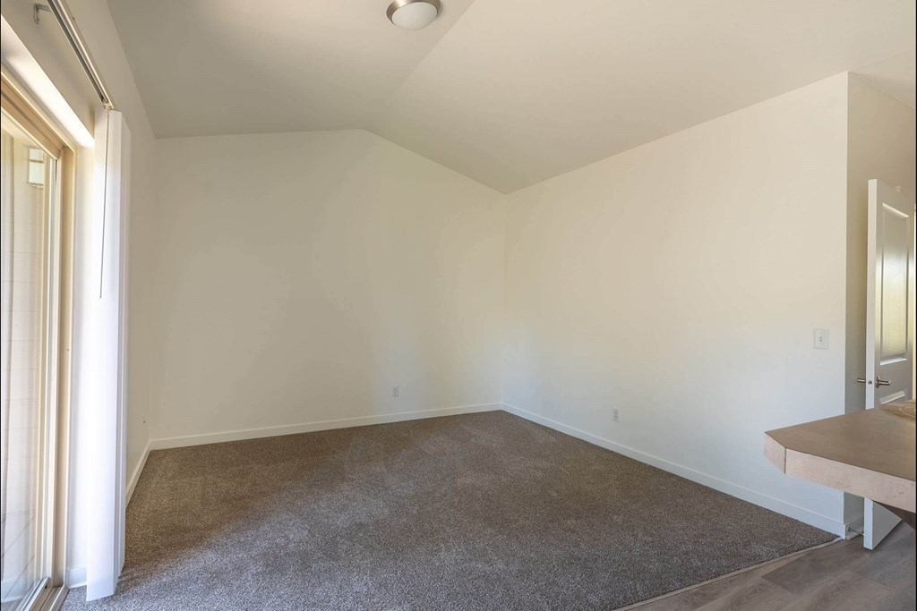 A room with a carpeted floor and a table at Stoneplace Apartment Homes, Molalla, 97038